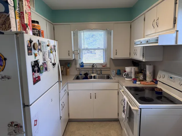 a kitchen with a white stove top oven sink and cabinets