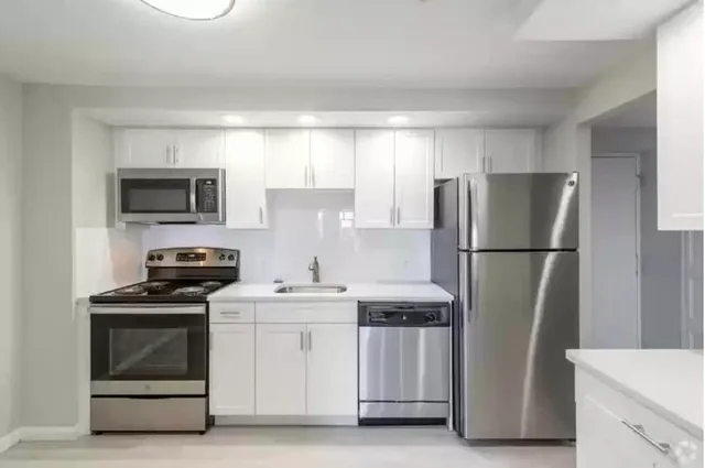 a kitchen with stainless steel appliances a refrigerator stove and microwave