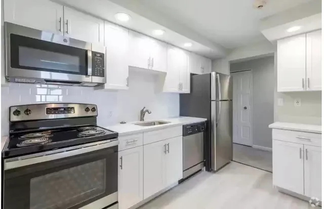 a kitchen with stainless steel appliances a stove a sink and a microwave
