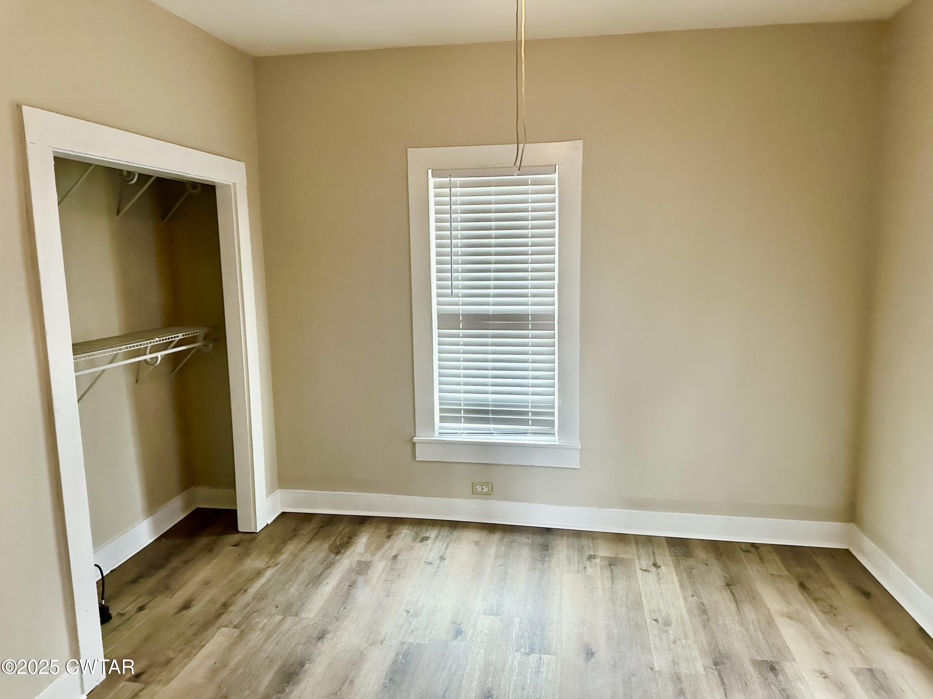 1509 Vine Street Humboldt, TN 38343 - Photo 6 of 9 a view of an empty room with wooden floor and a window