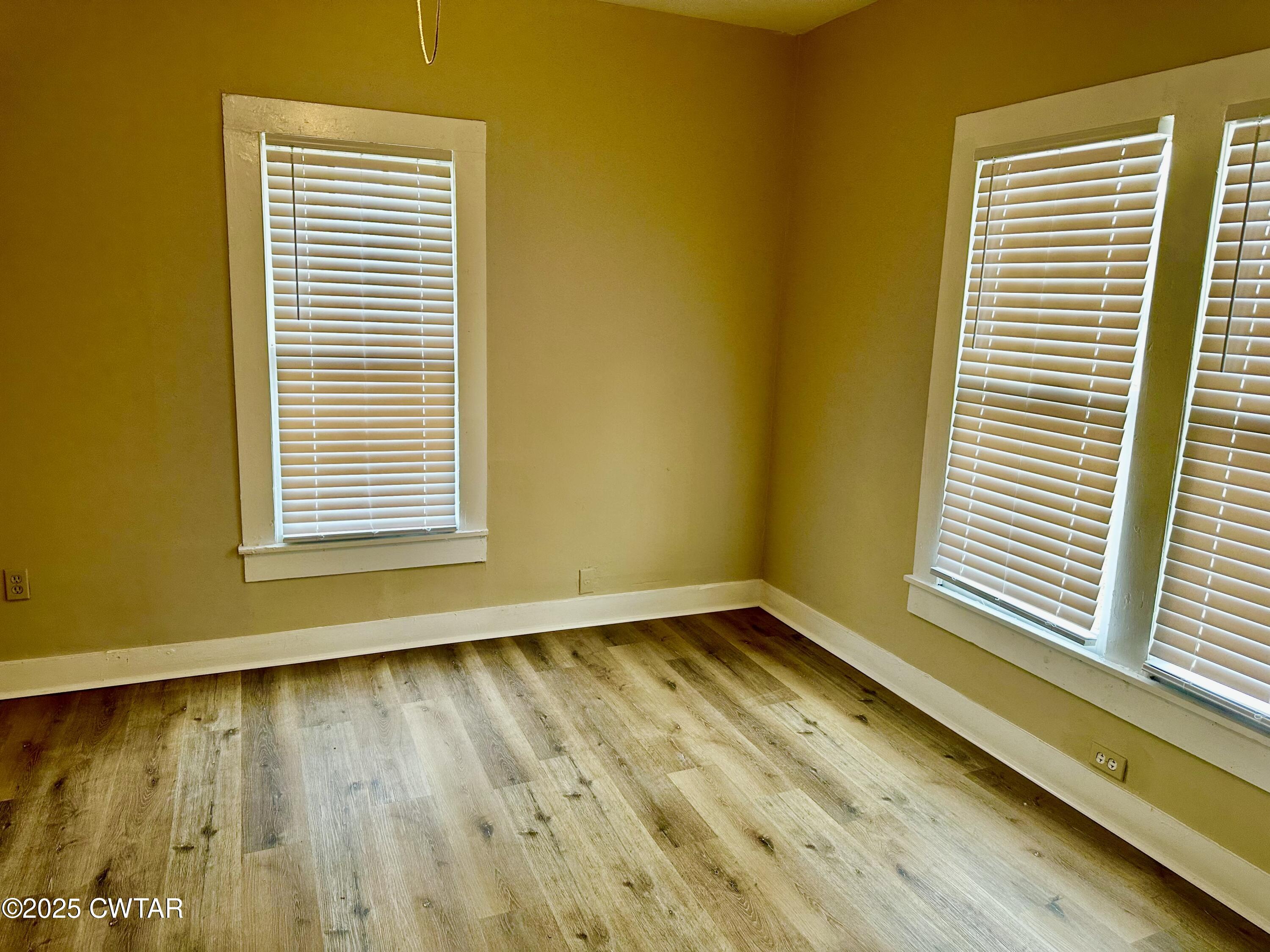 1509 Vine Street Humboldt, TN 38343 - Photo 7 of 9 a view of an empty room with a window and wooden floor