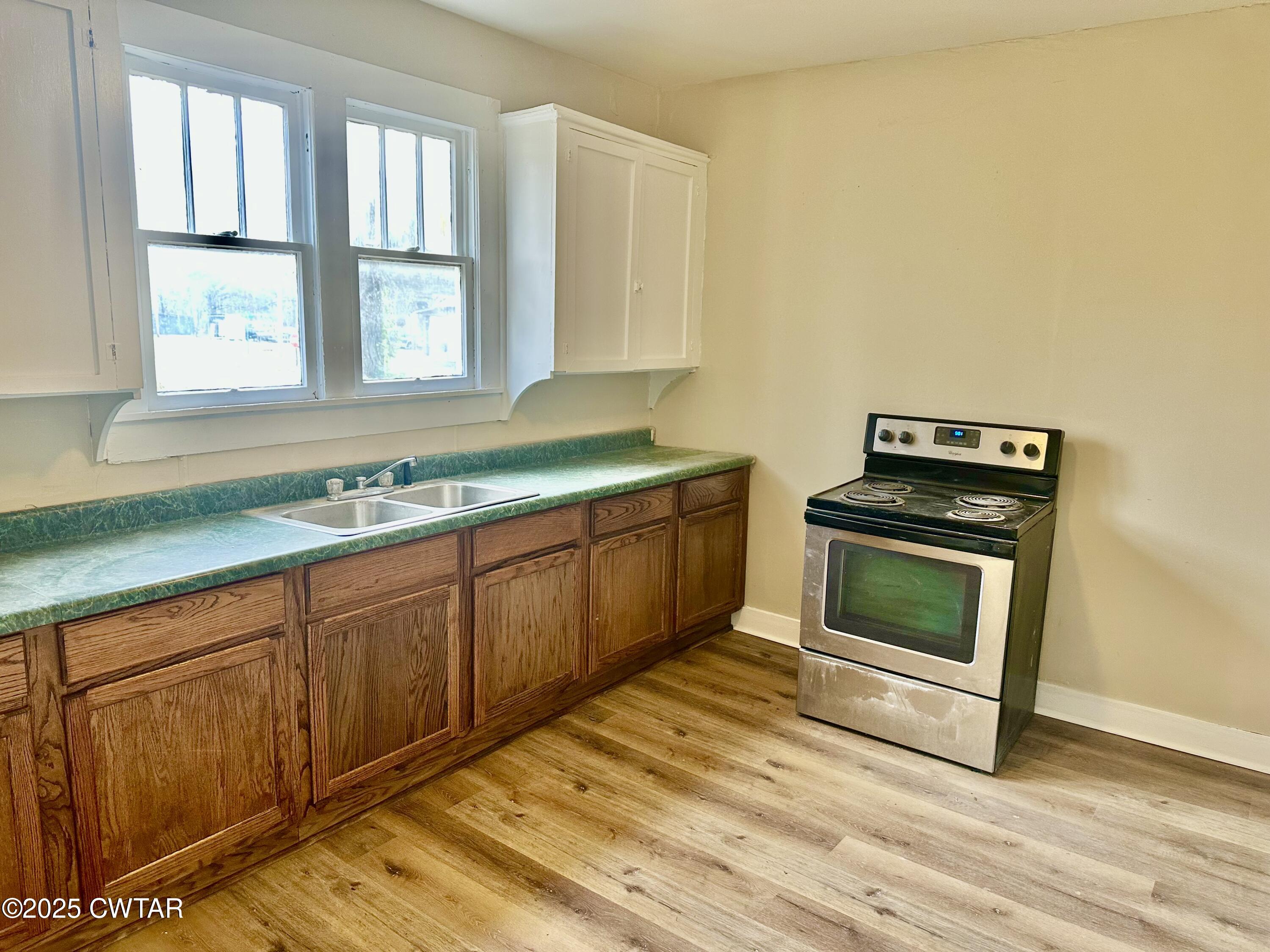 1509 Vine Street Humboldt, TN 38343 - Photo 9 of 9 a kitchen with granite countertop a stove a sink and a microwave