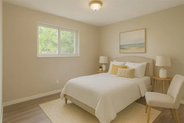 a bedroom with a bed and a lamp on dresser