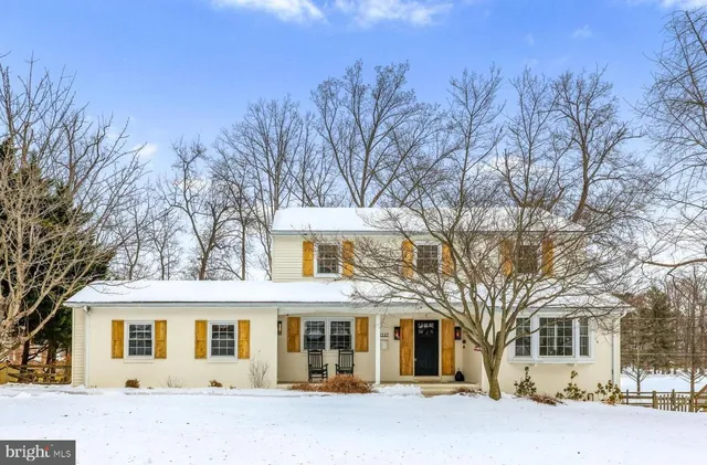 a front view of a house with a yard covered in snow