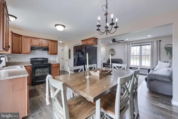 a view of a dining room with furniture a chandelier and wooden floor