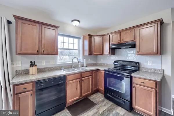 a kitchen with stainless steel appliances granite countertop a sink stove and cabinets