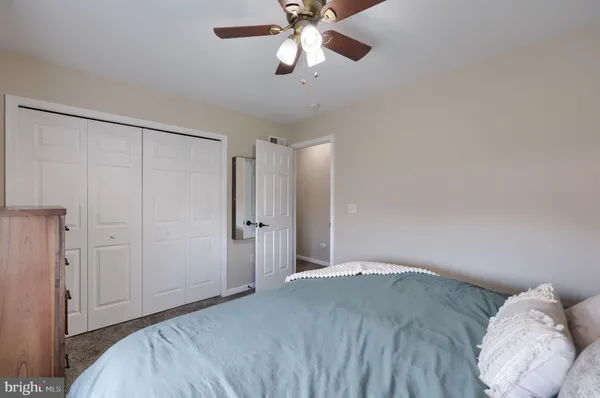 a bedroom with a bed and a chandelier fan
