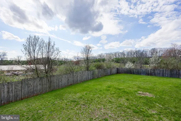 a view of a yard with a wooden fence