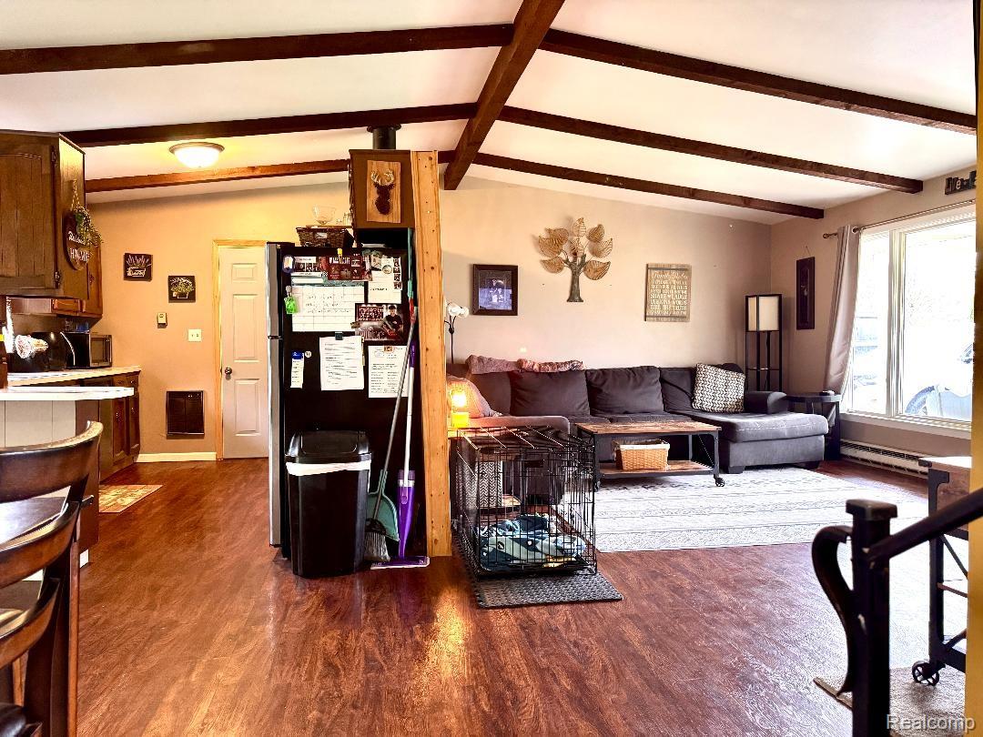 687 West Saginaw Road Mayville, MI 48744 - Photo 8 of 12 Living area featuring dark wood finished floors, a baseboard radiator, and lofted ceiling with beams