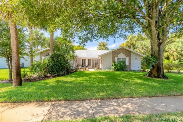 a front view of a house with a garden and yard