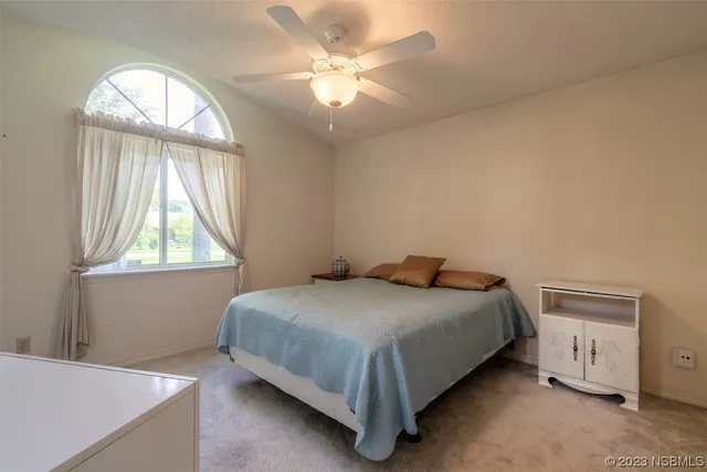 a spacious bedroom with a large bed and a chandelier