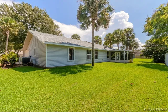 an aerial view of residential houses with outdoor space and trees