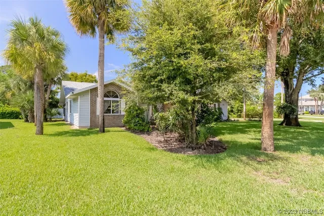 a view of a house with a yard and tree
