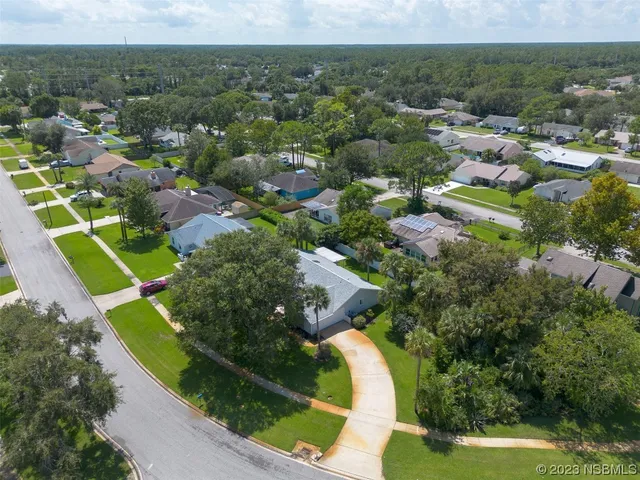 an aerial view of a house with a yard and lake view