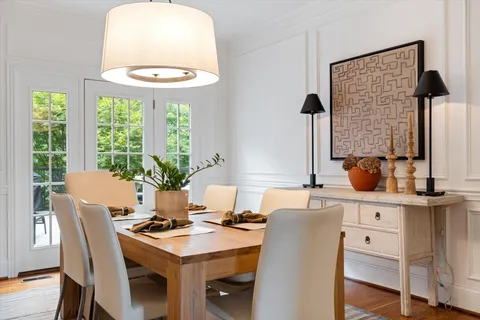 a dining room with furniture window and wooden floor
