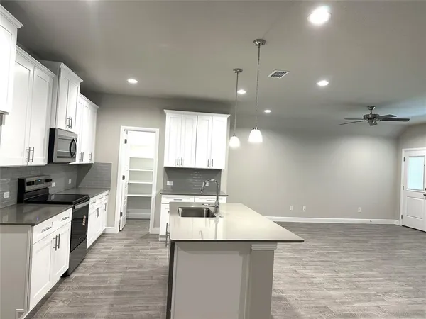 a kitchen with a stove a sink and a refrigerator