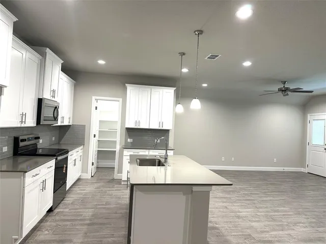 a kitchen with a stove a sink and a refrigerator