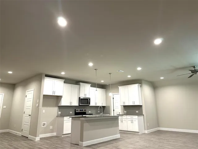 a kitchen with stainless steel appliances granite countertop a refrigerator and a stove top oven