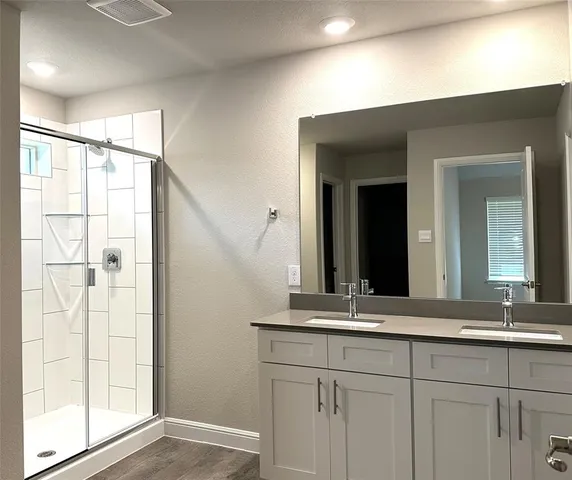 a bathroom with a double vanity sink and a mirror