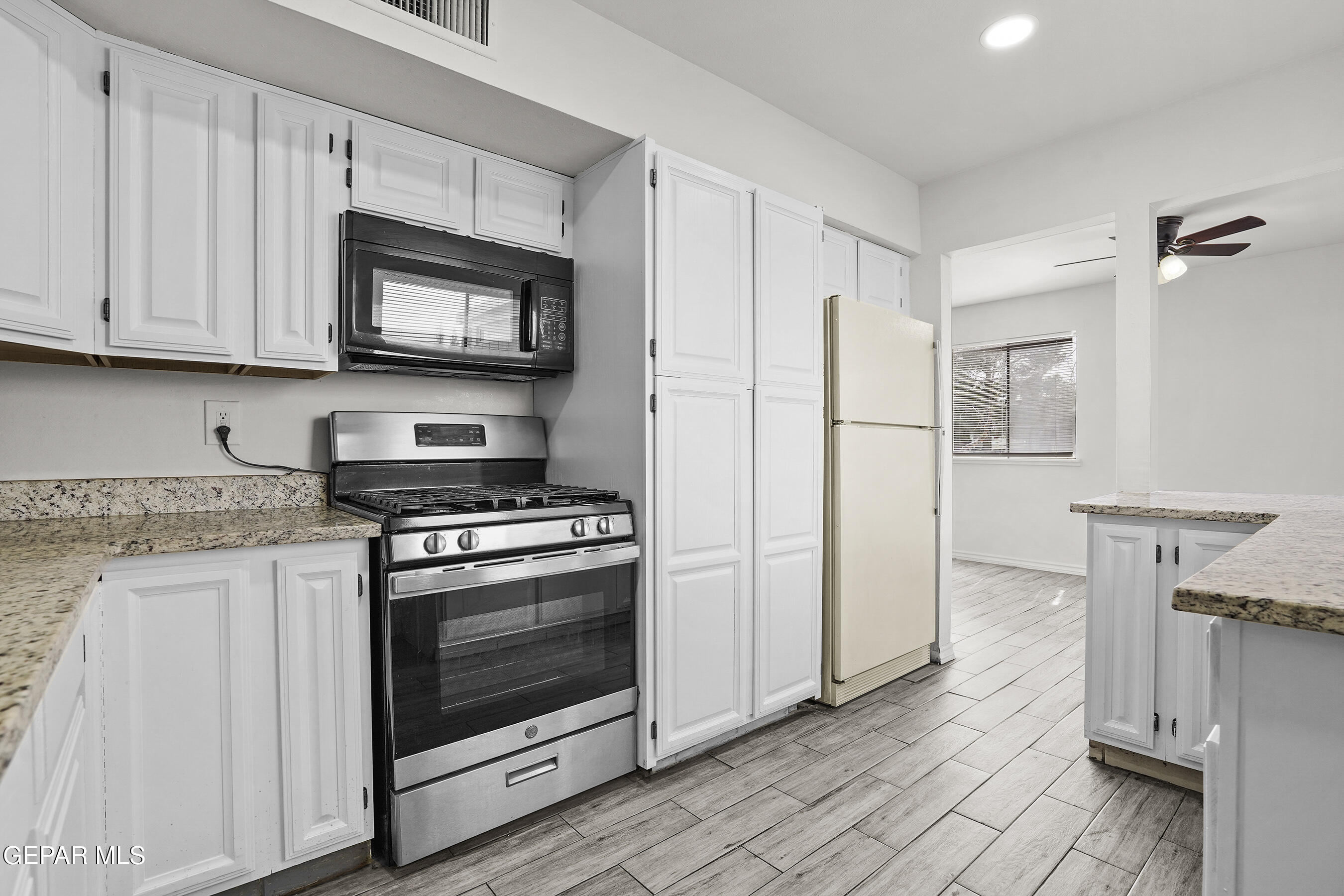 7809 Hemlock Street El Paso, TX 79925 - Photo 12 of 32 a kitchen with stainless steel appliances granite countertop a stove a refrigerator and a microwave