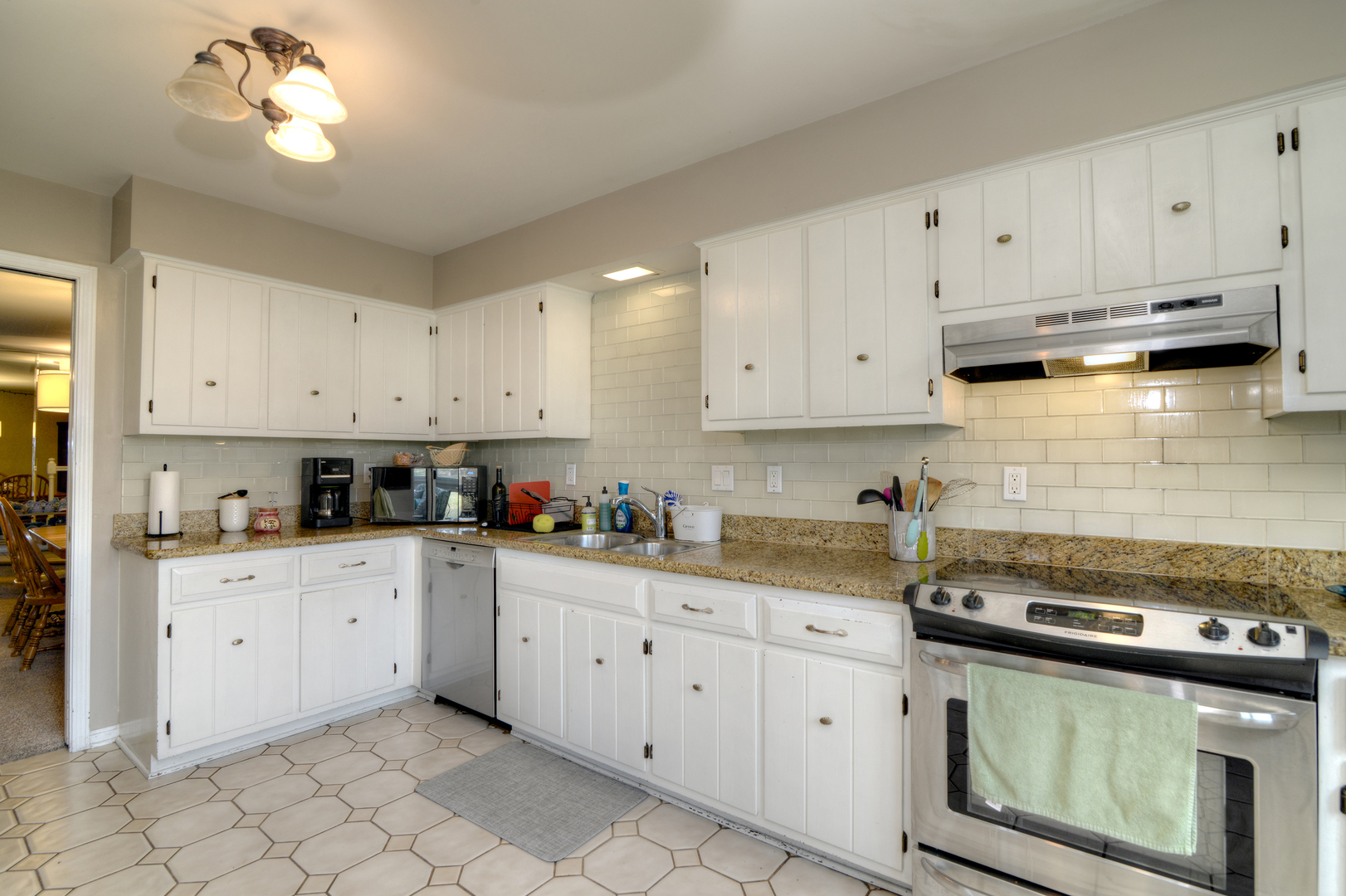 116 Dunham Place Commons, Unit 116 St. Charles, IL 60174 - Photo 10 of 26 a kitchen with granite countertop white cabinets white stainless steel appliances and sink
