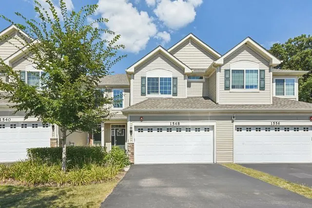 a front view of a house with a garden and plants