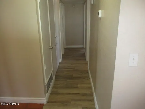 a view of a hallway with wooden floor