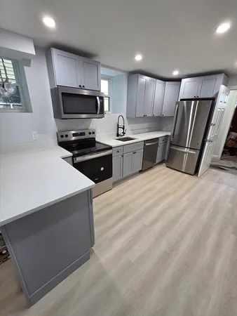 a kitchen with stainless steel appliances a refrigerator sink and microwave