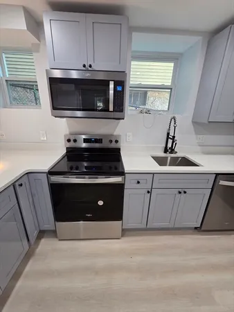 a kitchen with white cabinets appliances and a sink