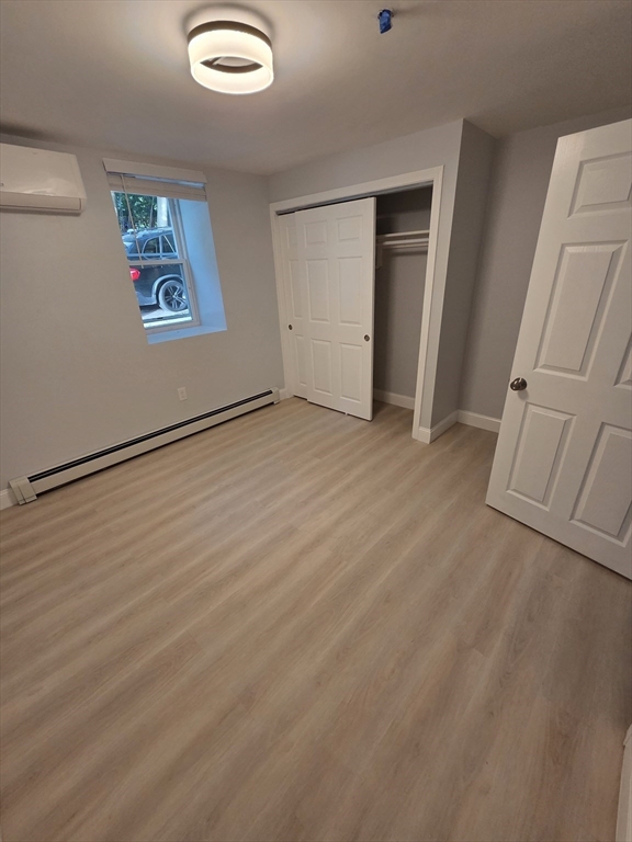 137 Centre Street, Unit B Boston, MA 02119 - Photo 9 of 10 an empty room with windows and closet