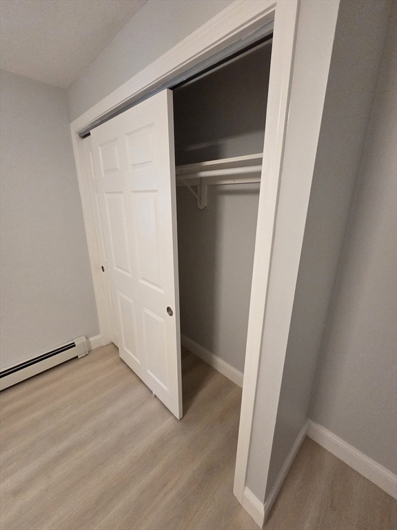 137 Centre Street, Unit B Boston, MA 02119 - Photo 10 of 10 an empty room with wooden floor and closet