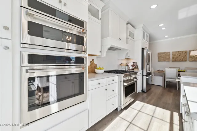 a kitchen with stainless steel appliances granite countertop a stove and white cabinets