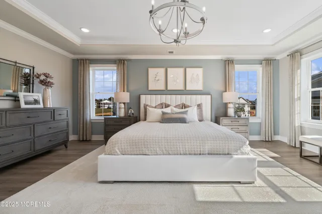 a spacious bedroom with a bed and a chandelier