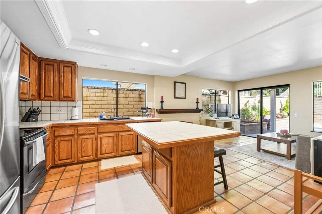 21902 Raintree Lane Lake Forest, CA 92630 - Photo 13 of 46 a large kitchen with stainless steel appliances kitchen island granite countertop a sink and cabinets