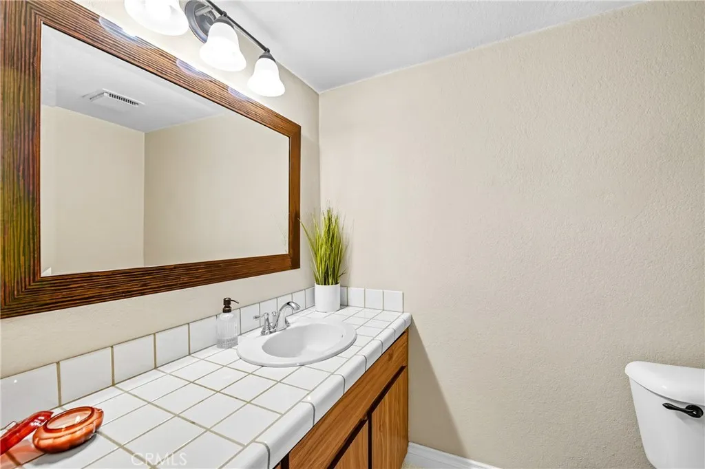 21902 Raintree Lane Lake Forest, CA 92630 - Photo 15 of 46 a bathroom with a granite countertop sink and a mirror