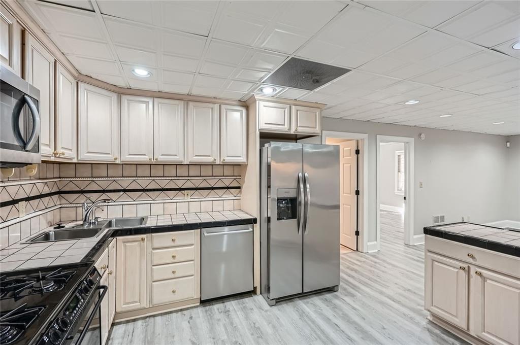 3330 Valley Vista Road Southeast Smyrna, GA 30080 - Photo 29 of 40 a kitchen with stainless steel appliances granite countertop a sink stove and refrigerator