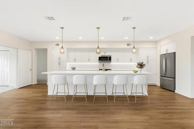 a large kitchen with a table chairs refrigerator and cabinets