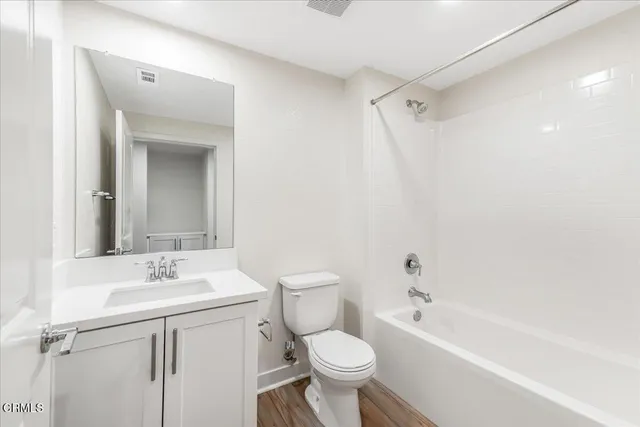 a bathroom with a toilet sink vanity tub and shower