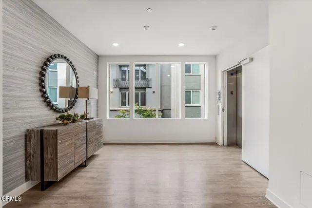 a living room with stainless steel appliances kitchen island granite countertop a refrigerator a stove a sink and a large window