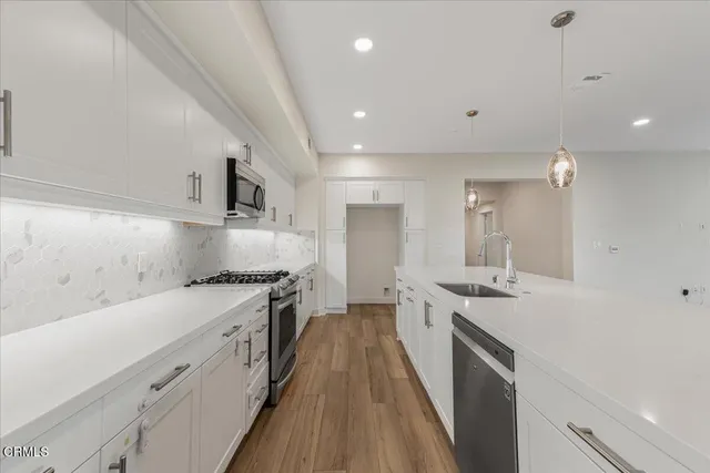 an open kitchen with a sink and wooden floor