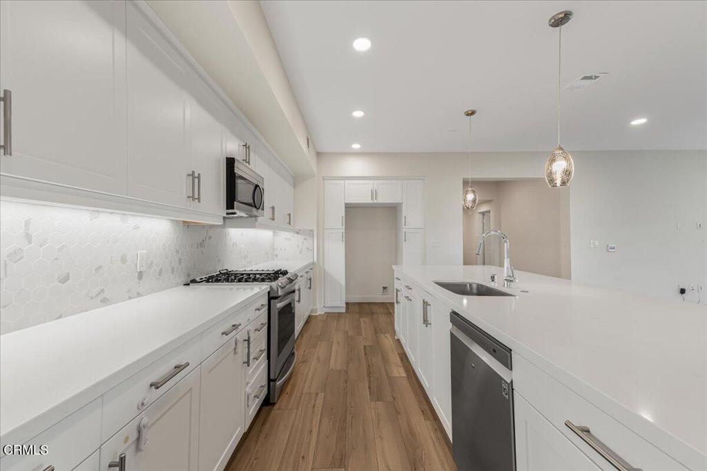 2830 Wagon Wheel Road, Unit 304 Oxnard, CA 93036 - Photo 7 of 45 an open kitchen with a sink and wooden floor