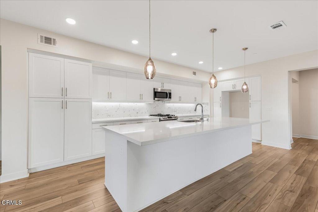 2830 Wagon Wheel Road, Unit 304 Oxnard, CA 93036 - Photo 9 of 45 a kitchen with kitchen island a sink stainless steel appliances and cabinets