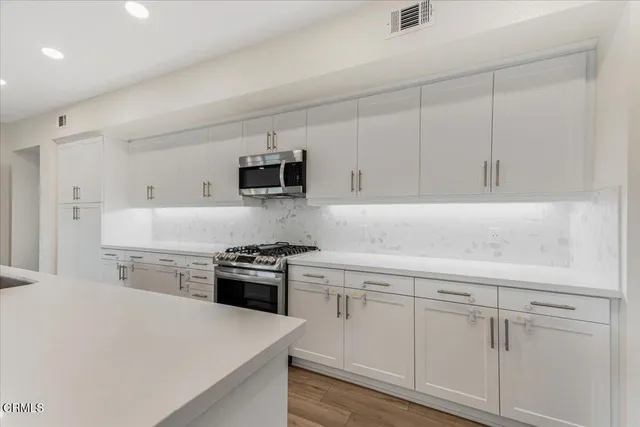 a kitchen with cabinets appliances a sink and a counter top