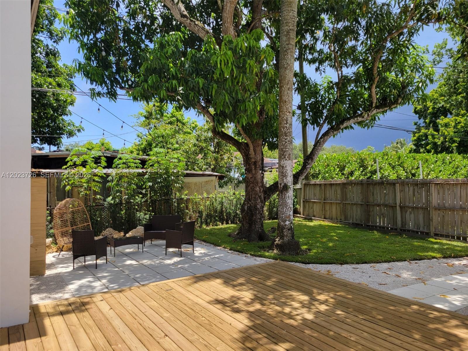 5866 Southwest 60th Street, Unit 3 Miami, FL 33143 - Photo 8 of 8 a view of a backyard with a potted plant and large trees