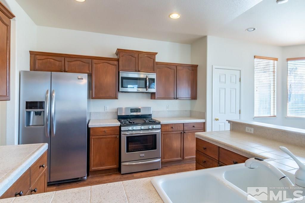 9575 Navigator Drive Reno, NV 89521 - Photo 4 of 13 a kitchen with stainless steel appliances granite countertop a refrigerator stove and sink