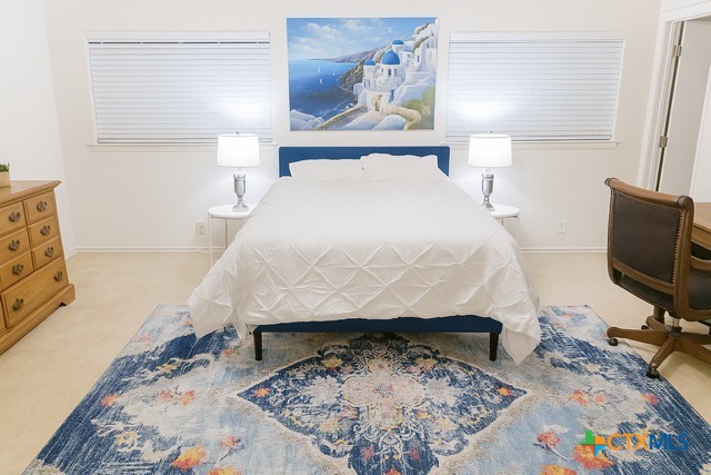 1054 Rolling Path New Braunfels, TX 78130 - Photo 8 of 14 a bed sitting in a bedroom next to a window with chair