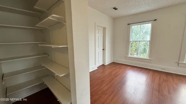 a view of a room with wooden floors and window
