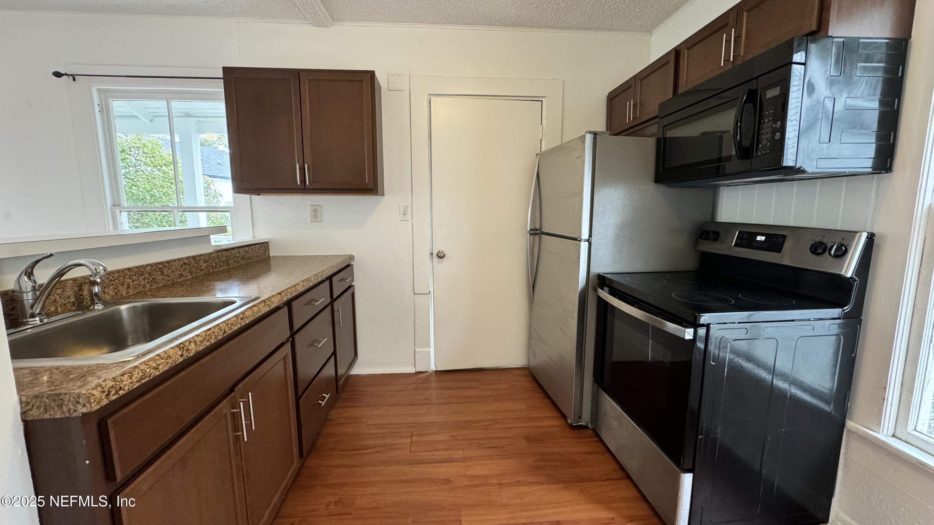 32 Sanford Street St. Augustine, FL 32084 - Photo 7 of 13 a kitchen with a refrigerator stove and sink