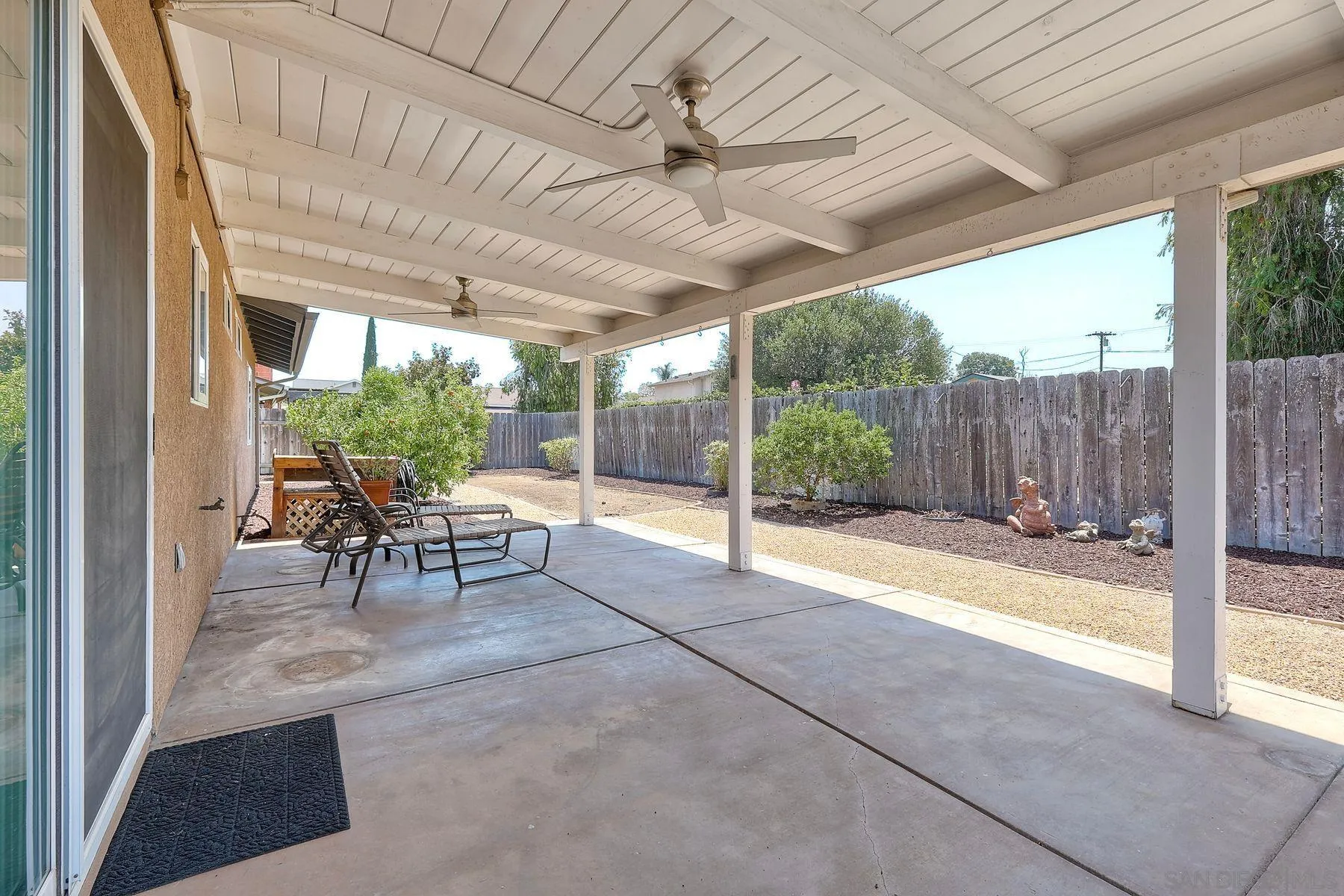 8850 Ellsworth Circle Santee, CA 92071 - Photo 25 of 29 a view of a patio with table and chairs and floor to ceiling window with wooden fence
