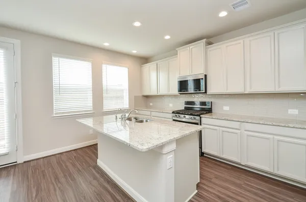 a kitchen with stainless steel appliances granite countertop a sink stove and microwave